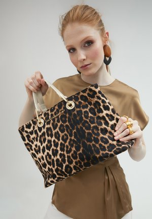 Leopardmønstret tasketaske med cremefarvede håndtag og guldfarvet hardware, lavet af tekstureret materiale. Bemærkelsesværdigt logo på forsiden.