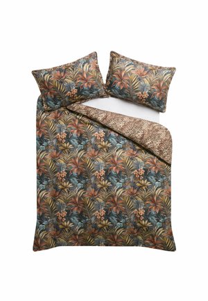 Parure de lit à motifs floraux et feuillages avec deux oreillers assortis, retournée dans un coin sur un imprimé animal marron et noir à taches.