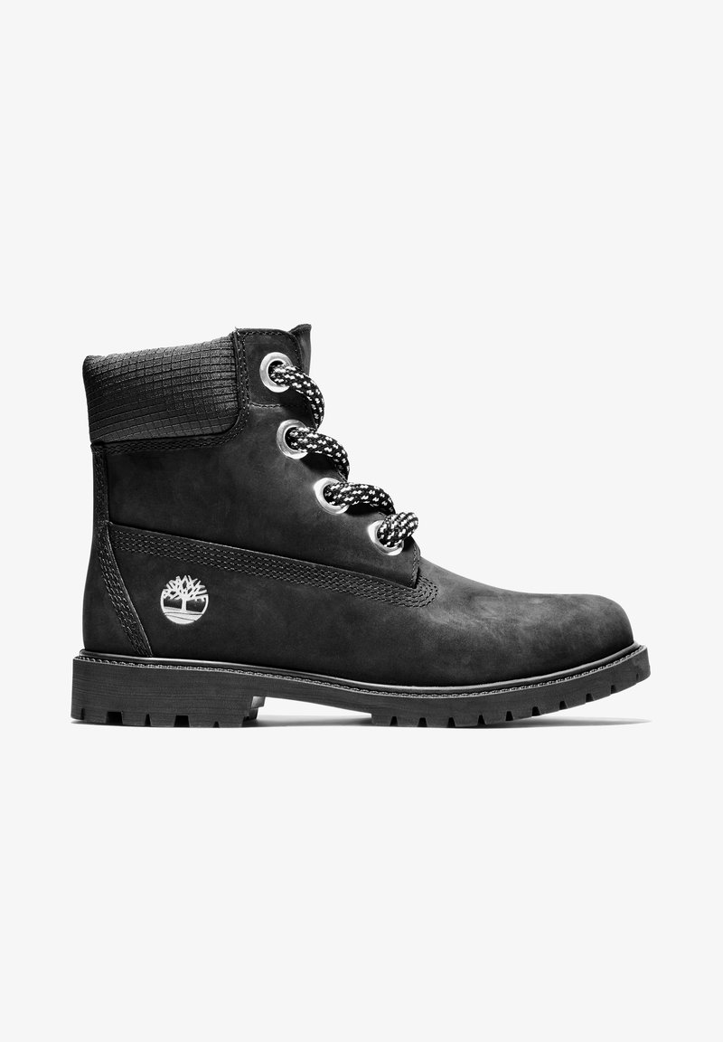 Bottine en cuir noir avec col rembourré, œillets métalliques, lacets à motifs, semelle robuste et logo d'arbre embossé sur le côté.