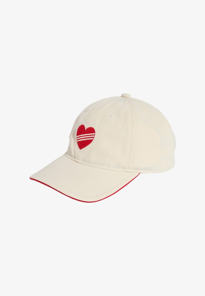 Crèmekleurige honkbalpet met gebogen klep, rood hartembleem en twee rode horizontale strepen. Rode accentbies langs de klep. De stof heeft een gladde textuur.