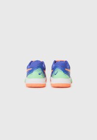 Lilla og grønne atletiske sko med oransje detaljer, mesh-overdel og teksturert gummisåle, med et mønstrete design på hælen.
