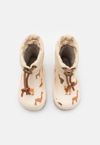 Bottes imperméables beige avec motif de lama, semelle en caoutchouc texturée et doublure en peluche. Cordon de serrage ajustable avec accents marron et finition lisse.