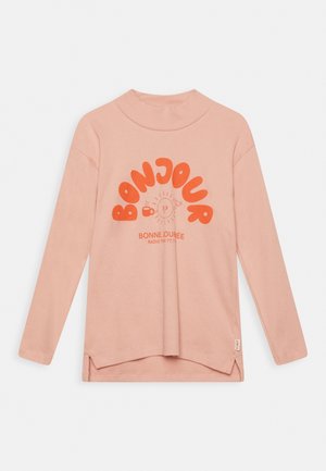 Jasnoróżowa koszula z długim rękawem i stójką, z kolorowym napisem "Bonjour" oraz zaokrąglonym dołem z bocznymi rozcięciami.