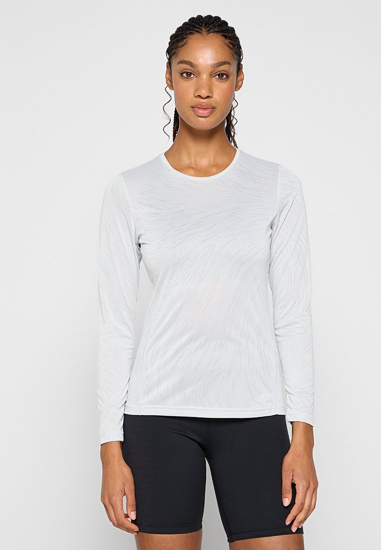 Długi rękaw, jasnoszara sportowa koszulka z subtelnymi wzorami faktury, okrągły dekolt, w połączeniu z czarnymi szortami.