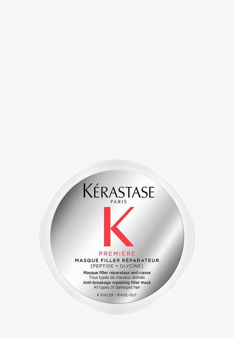 Kérastase haarmasker in een ronde witte container met een zilveren deksel. Bevat een rood "K"-logo, de productnaam in zwart en tweetalige tekst.