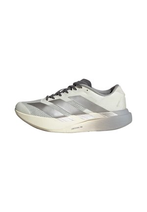 Zapatilla deportiva blanca y gris claro con cordones negros, tres franjas plateadas en el lateral y una suela gruesa y acolchada con la etiqueta "Lightstrike Pro."