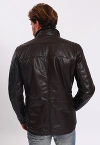 Braune Lederjacke mit glatter Textur, hoher Kragen und gesteppten Details, von hinten betrachtet.
