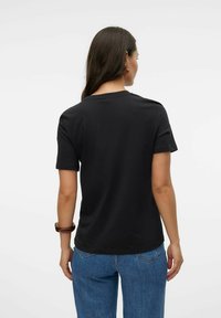 Schwarzes Baumwoll-T-Shirt mit kurzen Ärmeln und rundem Halsausschnitt, mit einer lockeren Passform und glatter Textur, von hinten betrachtet.