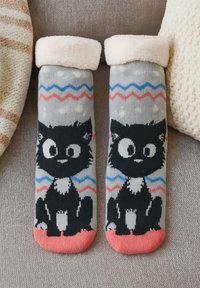 Calze grigie con design di un gatto nero dai grandi occhi. Bordo rosa a coste e motivi a zigzag in blu e rosso. Texture morbida.
