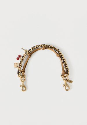 Bandoulière de sac en cuir tan et chaîne dorée avec fermoirs dorés et breloques attachées, notamment des dés et la tour Eiffel.