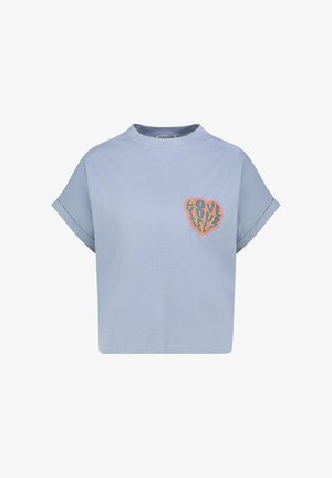 Light blue cropped t-shirt with rolled short sleeves and a colorful heart-shaped patch on the chest saying "Love Yourself."
