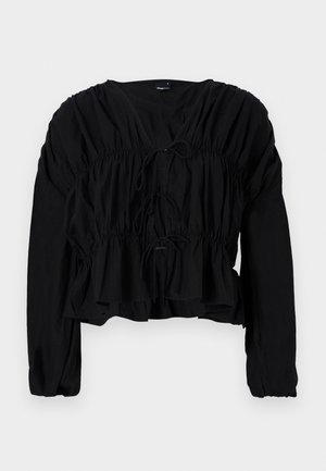 Schwarze Bluse mit langen Ärmeln, gerafftem Bund und Frontknoten. Sie hat einen V-Ausschnitt und ist lässig geschnitten mit einem strukturierten Stoff.