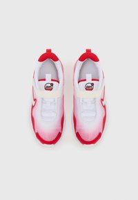 Zapatillas Nike Air Max en rojo y blanco con parte superior de malla, patrón de rejilla, collar acolchado y tira de velcro en el mediopie.