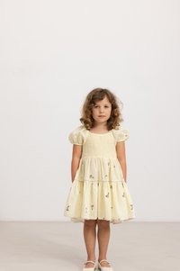 Gelbes Kleid mit Puffärmeln, gerafftem Oberteil und floralen Stickereien. Design mit gestuften Röcken, leichtem Stoff und knieumspielender Länge.