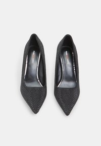 Cizme negre cu vârful ascuțit, acoperite cu mici strasuri, având o căptușeală interioară netedă de culoare neagră și un design elegant al tocului.