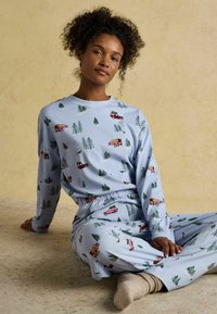 Modré pyžamové súprava s dlhými rukávmi a elastickým pásom, zdobená ilustráciami stromov a nákladných áut, vyrobená z mäkkého bavlneného materiálu.