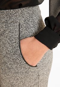 Broek met een houndstooth patroon in grijs en zwart, met een slim fit, textuurstof en een elegante zak met zwarte afwerking.