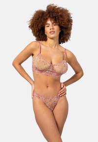 Korsetti pitsi setti, jossa on läpinäkyvää, kukka-embroiderya pehmeissä vaaleanpunaisissa sävyissä. Sisältää säädettävät hihnat ja rintaliivimäisen yläosan, joka on yhteensopiva thon kanssa.