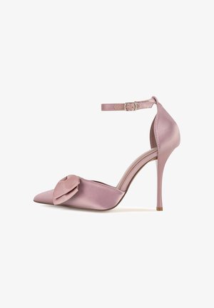 Rozā satīna augstpapēžu kurpe ar smailu purngalu un dekoratīvu lentes akcentu. Iekļauj potīti aptverošu jostu un plānu stiletto papēdi.