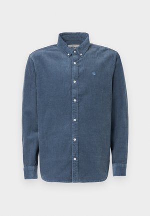 Plava kedrovina košulja s dugim rukavima, dugmadi dolje, i prednjim preklopom. Sadrži mali logo izvezen na prsima.