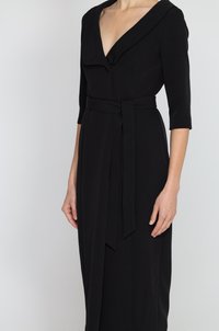 Czarna sukienka z głębokim dekoltem w kształcie litery V, trzema ćwiartkami rękawów i związaną talią. Wykonana z gładkiego materiału z drapowanym kołnierzem i minimalistycznym wzornictwem.