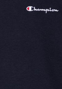 Maglietta in cotone blu navy con un piccolo logo "Champion" ricamato bianco, texture liscia con un design classico a girocollo.