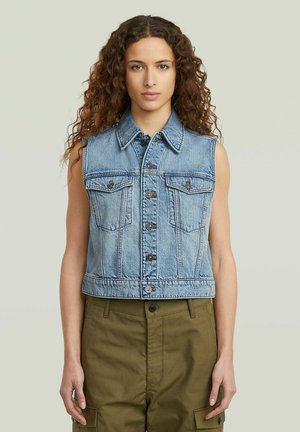 Veste sans manches en denim bleu clair, avec un bouton devant, deux poches poitrine et un design cropped. Texture lisse avec des coutures visibles.