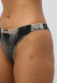 Στρινγκ εσώρουχο σε στυλ ντένιμ με ασπρόμαυρο γκρι διαβάθμιση. Ελαστική μέση με λογότυπο. Απαλή υφή με εφαρμοστή σχεδίαση.