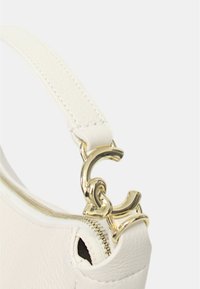Dettaglio di una borsa in pelle bianca con cerniera in tonalità oro e manico con catena spessa. Texture liscia e linee pulite.