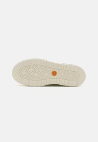 Semelle extérieure en caoutchouc blanc avec un motif de traction texturé et un logo circulaire orange au centre, idéale pour l'adhérence et la durabilité.