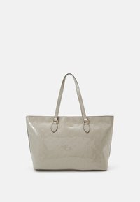 Sac cabas en cuir verni beige avec motif floral embossé, silhouette plate, deux anses d'épaule et accessoires métalliques dorés.