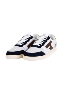 Sneaker bianche con accenti in suede blu navy, tomaia in rete testurizzata e dettaglio del logo marrone. Design classico con lacci piatti e suola color crema.