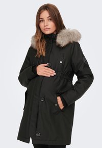Juoda nėštumo parka su pūkine dygsniuota kapu, reguliuojamu juosmeniu, mygtukų užsegimu ir šoninėmis kišenėmis. Tekstūruota medžiaga su lygiu paviršiumi.