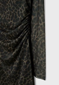 Tessuto con stampa leopardata nera e beige, con texture arricciata, finitura liscia, design drappeggiato e silhouette fluida.