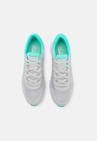 Chaussures de sport grises avec un dessus en maille, accents teal sur le col et la semelle intérieure, bout arrondi et design à lacets. Semelle légère et rembourrée.