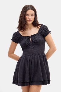 Robe noire avec des manches bouffantes courtes, un corsage froncé, un détail en trou de serrure à l'avant et une jupe superposée. Fabriquée en tissu texturé.