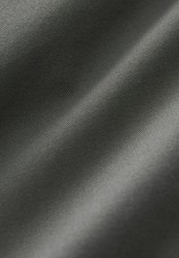 Tela gris oscuro con una superficie suave y texturizada que muestra un ligero brillo, presentando un patrón de tejido apretado y sutiles ondulaciones.