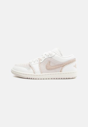 Adidași albi din material din suede și piele, cu accente roz, design cu șireturi, vârf rotunjit și logo pe lateral cu detalii texturate.