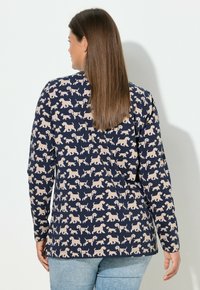 Marineblaues Langarmshirt mit cremigem Hundemuster, rundem Ausschnitt und geradem Schnitt; weicher, leichter Stoff mit glatter Textur.