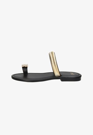 Sandalo nero flat con sottile anello per le dita con strass e ampia fascia metallica dorata sul piede.