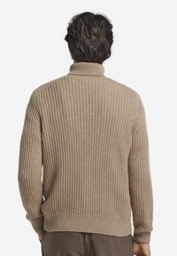 Beżowy sweter prążkowany z wysokim kołnierzem i długimi rękawami. Tekstura jest dziana z miękkim wykończeniem, prezentując prosty, klasyczny design.