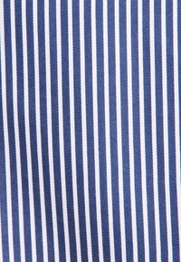 Motivo a righe verticali blu e bianche su tessuto intrecciato, uniformemente distanziato e costante in larghezza e colore.