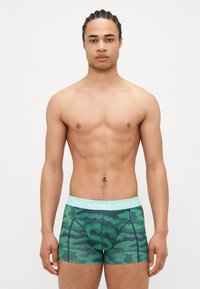 Grün gemusterte Boxershorts mit einem blauen Bund und dem "JACK & JONES"-Logo. Der Stoff hat eine weiche Textur und ein enganliegendes Design.