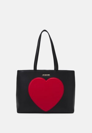 Czarna torba typu tote z dwoma uchwytami i dużym czerwonym sercem na przodzie, z małym złotym napisem "Love Moschino" nad sercem.