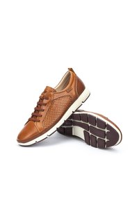 Zapatillas de cuero marrón con un lado de malla texturizada, cordones planos, suela acolchada y acentos en el talón y suela de un marrón oscuro contrastante.