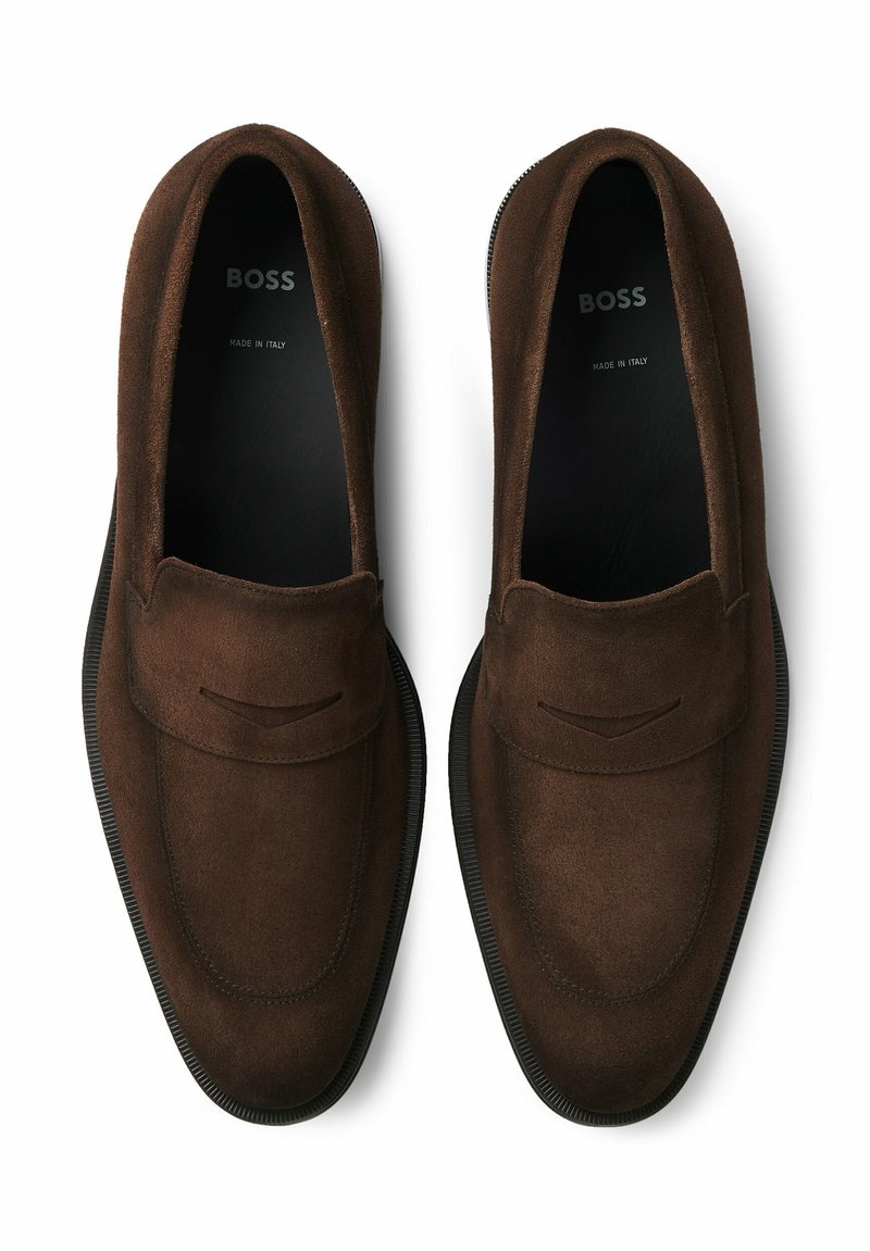 Mocassins en daim marron avec une semelle en caoutchouc, dotés d'un design cousu et d'accents subtils. Marqués "BOSS" à l'intérieur, fabriqués en Italie.