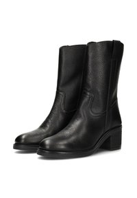Botines de cuero negro con acabado texturizado, puntera redonda y tacón bajo apilado. Presentan costuras laterales y diseño fácil de poner.