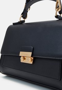 Sac à main en cuir noir au design structuré, doté de quincaillerie dorée et d'un détail de fermoir. Texture lisse avec un subtil éclat.