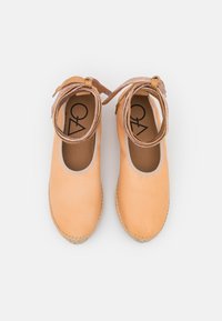 Espadrilhas de couro castanho claro com biqueira arredondada, acabamento bege e tiras de tornozelo trançadas em tom castanho. Sola de juta natural com detalhes de costura.