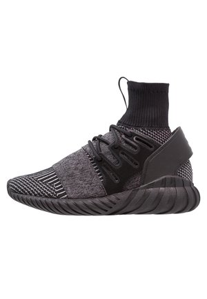 Black and gray high-top athletic sneaker with knit fabric, elastic ankle collar, lace-up design, strap over midfoot, and thick sculpted sole.